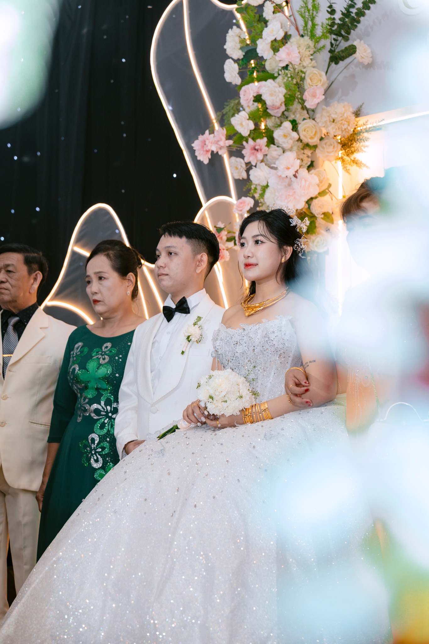 cô dâu chú rể cùng gia đình trên sân khấu