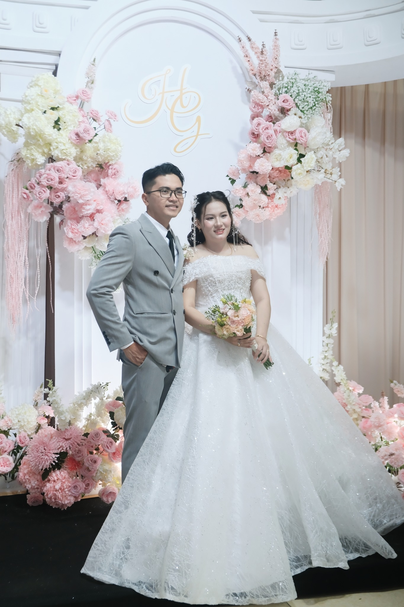 cô dâu chú rể đứng chụp ảnh