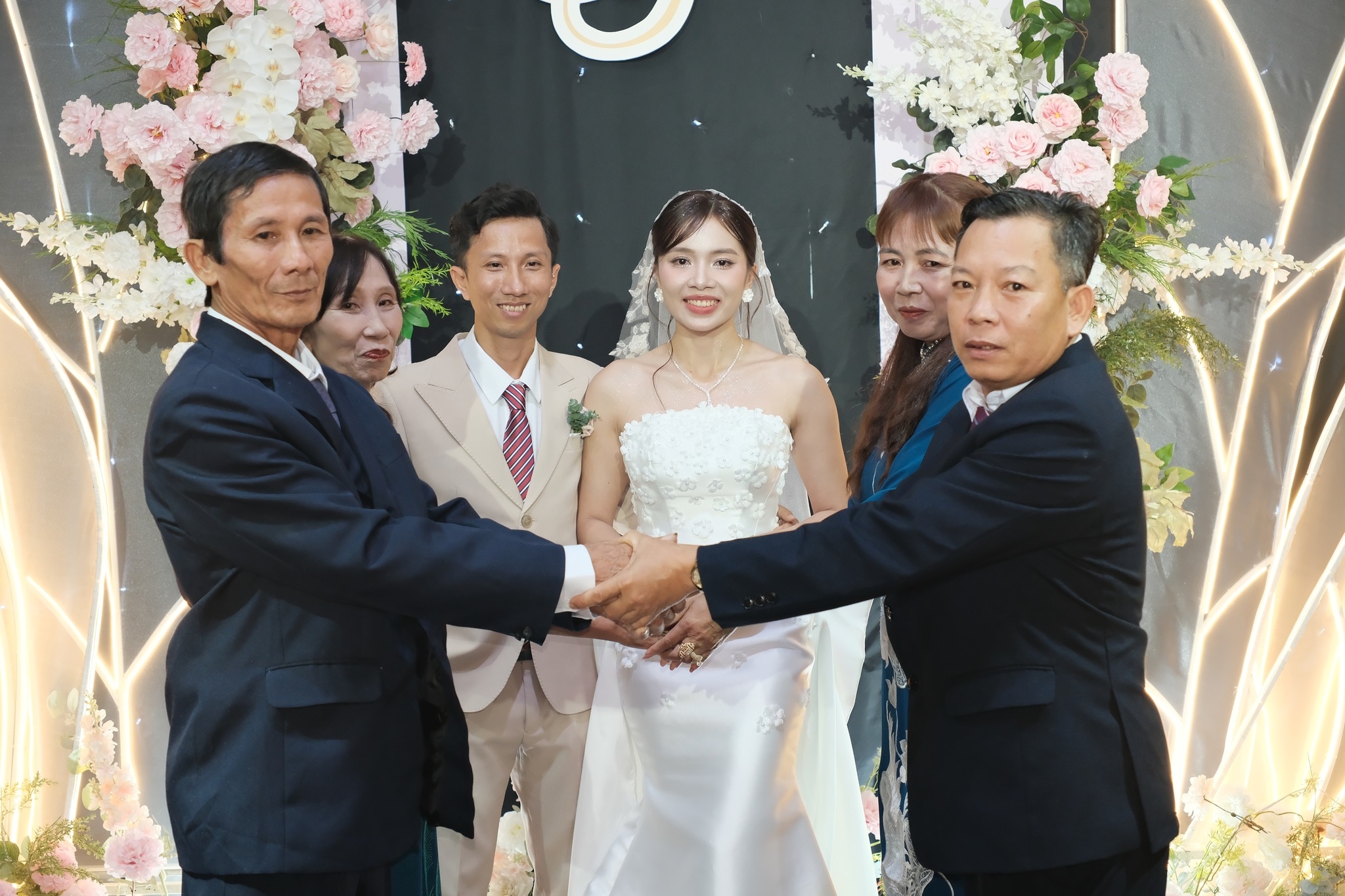 cô dâu chú rể và hai bên gia đình bắt tay nhau