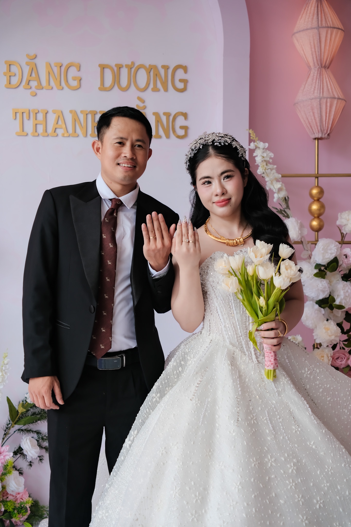 cô dâu chú rể chụp ảnh trước backdrop