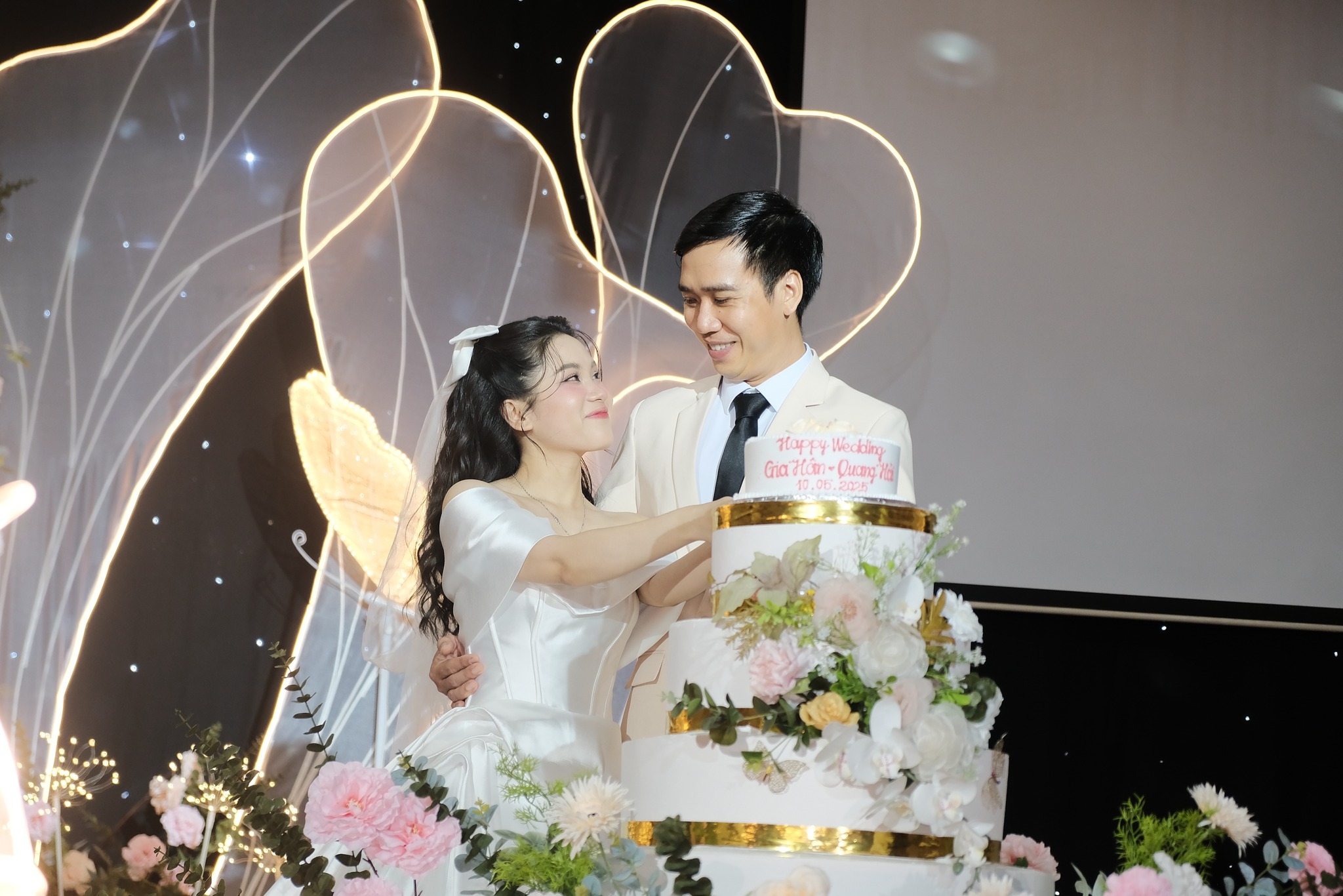 Khoảnh khắc cô dâu chú rể cắt bánh cưới trong không gian lãng mạn tại lễ cưới ngày 10/5/2025