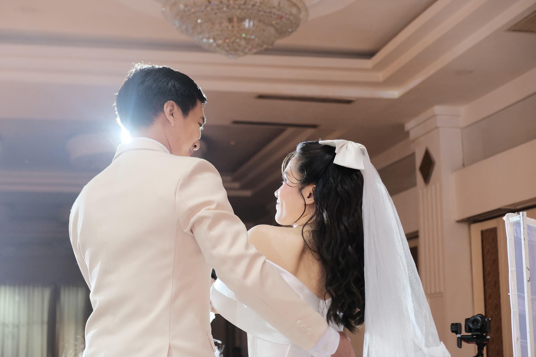 ô dâu và chú rể khiêu vũ ngọt ngào dưới ánh đèn trong lễ cưới tại nhà hàng Sun Palace